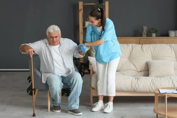 Nurse Helping Senior Man Stick Stand Armchair Home — Stock Photo, Image