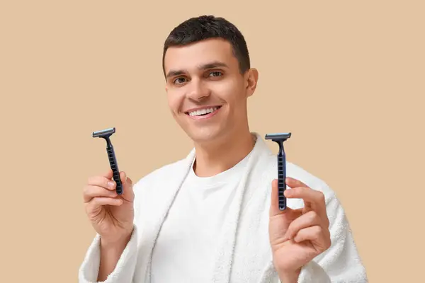 Portrait Handsome Young Man Bathrobe Shaving Razors Beige Background — Stock Photo, Image