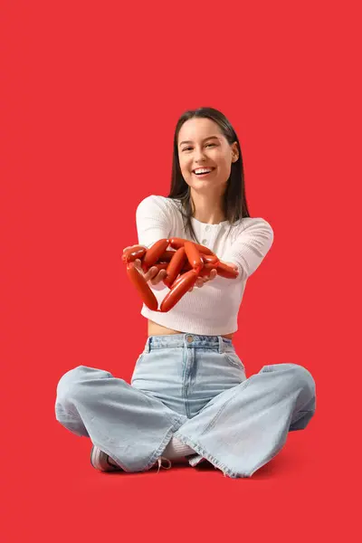 Giovane Donna Con Gustose Salsicce Seduta Sfondo Rosso — Foto Stock