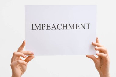 Beyaz arka planda IMPEACHMENT pankart posteri tutan kadın