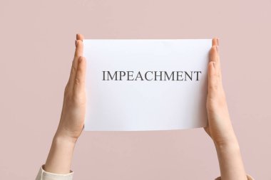 Woman holding IMPEACHMENT picket poster on pink background clipart