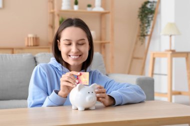 Evde kredi kartı ve kumbarası olan güzel bir kadın.