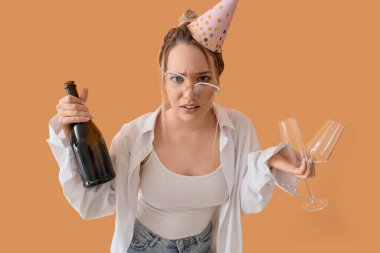 Bej arka planda doğum günü partisinden sonra akşamdan kalma ve şampanya içen genç bir iş kadını.