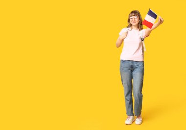 Sarı arka planda Fransız bayrağı olan bir kız öğrenci.