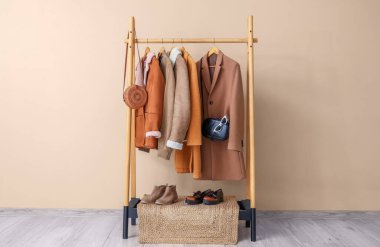 Şık kıyafetler ve bej duvarın yanında şık ayakkabılar.