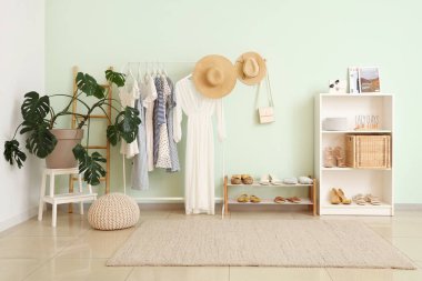 Şık giysili, çiçekli ve raflı aydınlatma odasının içinde.