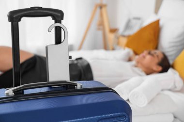 İş kadınının otel odasındaki kapı kollu bavul, yakın plan.