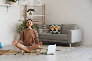 Evde meditasyon yapan güzel bir kadın.