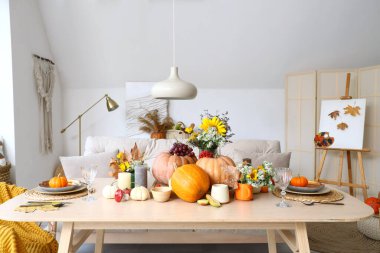 Sonbahar ayarı ve balkabakları olan yemek masası.