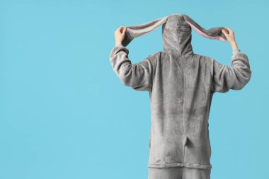 Mavi arka planda tavşan kostümlü, güzel, genç ve mutlu bir kadın. Paskalya kutlaması