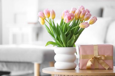 Uluslararası Kadınlar Günü için laleli vazo ve hediye kutusu yatak odasında, yakın plan.