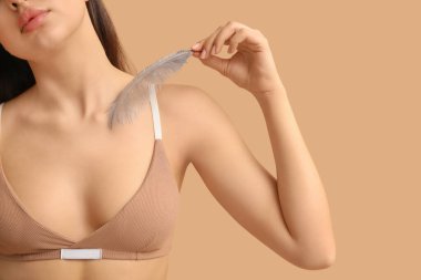 Kahverengi arka planda yumuşak tüylü genç bir kadın. Epilasyon kavramı