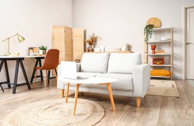 Oturma odasının içinde kanepe ve işyeri var.