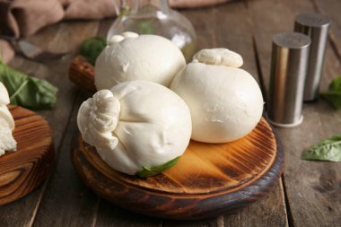 Tahta arka planda fesleğenli lezzetli Burrata peyniri.