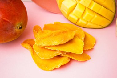 Pembe masada kurutulmuş mango dilimleri.