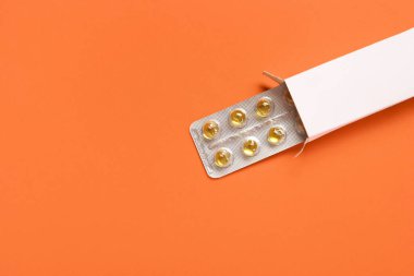 Sarı haplar turuncu arka planda su topladı.