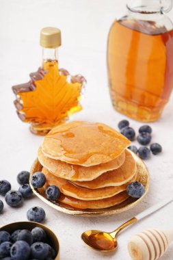 Beyaz arka planda yaban mersinli ve akçaağaç şuruplu lezzetli krepler.