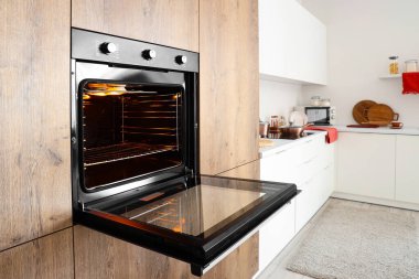 Modern mutfakta ahşap mobilya ve fırın.