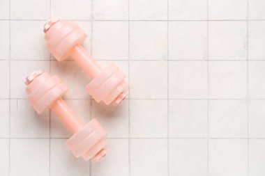 Beyaz seramik zemin üzerinde pembe halterler