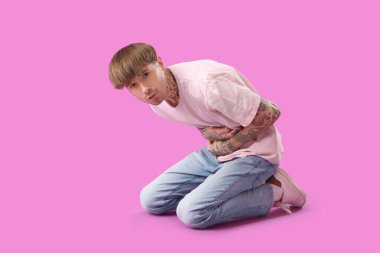 Mor arka planda karın ağrısı çeken genç bir adam.