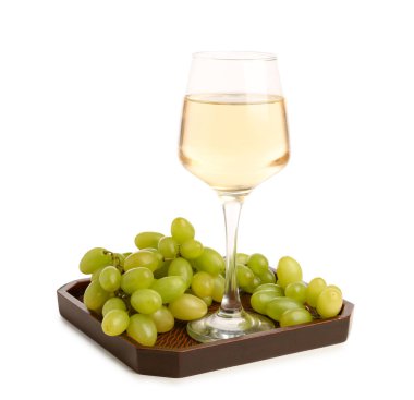 Tahta tahta tahta, üzüm ve beyaz arka planda bir bardak şarap.