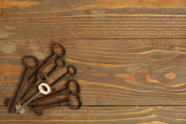 Ahşap arka planda paslı olanlar arasında yeni bir anahtar. Eşsizlik kavramı