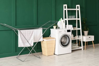 Çamaşır sepeti, kurutma makinesi ve çamaşır makinesi olan odanın içi.