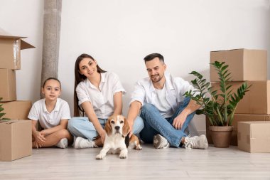 Taşındığı gün ışık duvarının yanında oturan mutlu bir aile.