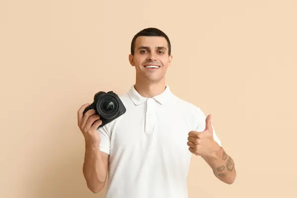 Modern Kameralı Erkek Fotoğrafçı Bej Arka Planda Başparmağını Kaldırıyor — Stok fotoğraf