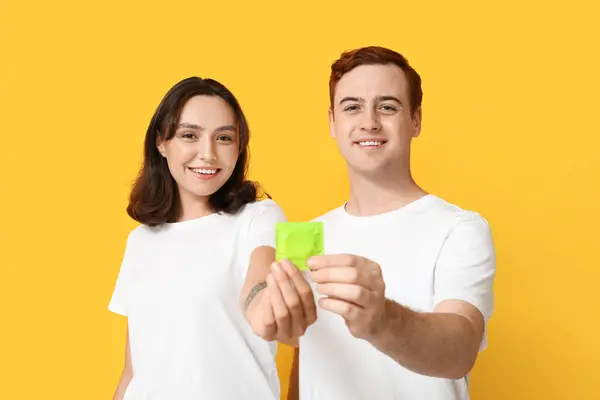 Young Couple Condom Yellow Background Safe Sex Concept — Stock Photo, Image