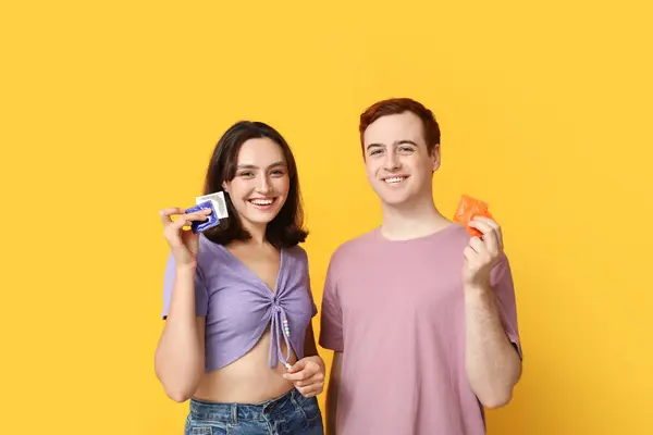 Young Couple Condoms Yellow Background Safe Sex Concept — Stock Photo, Image