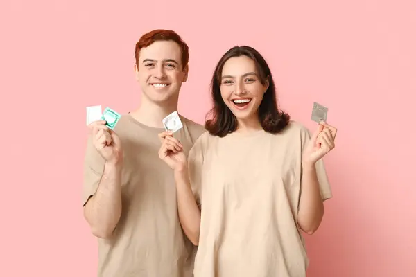 Young Couple Condoms Pink Background Safe Sex Concept — Stock Photo, Image