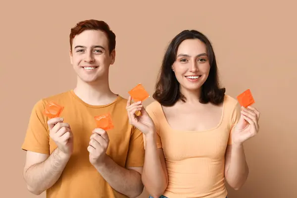 Junges Paar Mit Kondomen Auf Beigem Hintergrund Sicheres Sex Konzept — Stockfoto