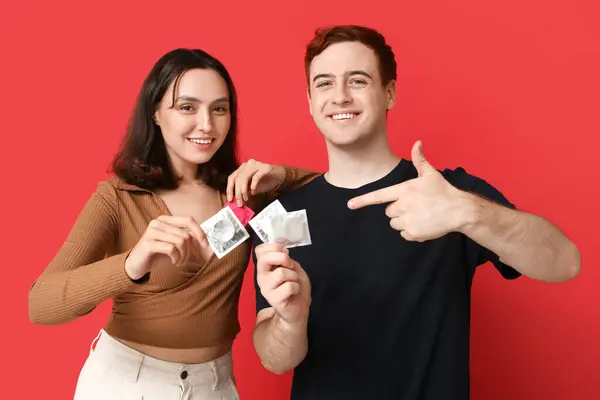 Young Couple Condoms Red Background Safe Sex Concept — Stock Photo, Image