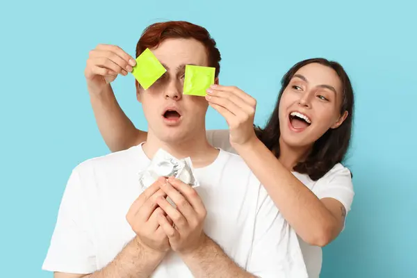 Lustiges Junges Paar Mit Kondomen Auf Blauem Hintergrund Sicheres Sex — Stockfoto