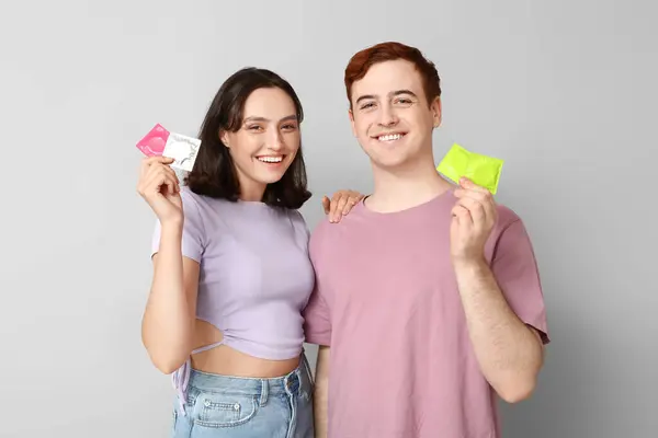 Young Couple Condoms Grey Background Safe Sex Concept — Stock Photo, Image