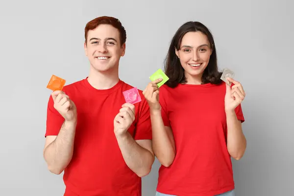 Young Couple Condoms Grey Background Safe Sex Concept — Stock Photo, Image