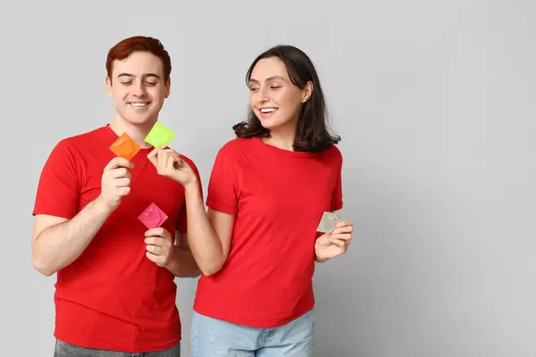 Junges Paar Mit Kondomen Auf Grauem Hintergrund Sicheres Sex Konzept — Stockfoto