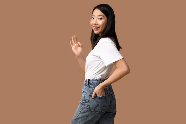 Mooi Jong Gelukkig Aziatisch Vrouw Stijlvolle Jeans Tonen Gebaar Bruine — Stockfoto
