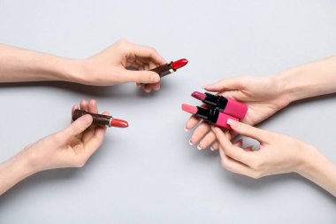 Gri arkaplanda ruj izi olan kadın elleri.