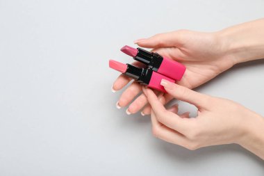 Gri arkaplanda ruj izi olan kadın elleri.