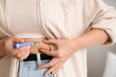 Yatak odasında tükenmez kalem kullanan diyabetik bir kadın.