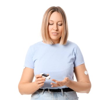 Beyaz arka planda glukometre kullanan diyabetik kadın