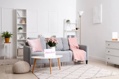 Uluslararası Kadınlar Günü için vazoda güller ve kartla oturma odasının içinde.