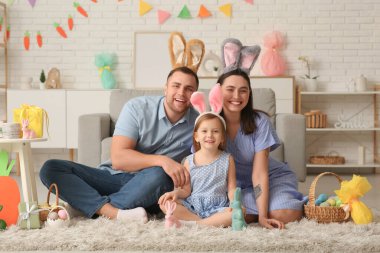 Tavşan kulaklı mutlu aile Paskalya hediyeleri evde yerde oturuyor.