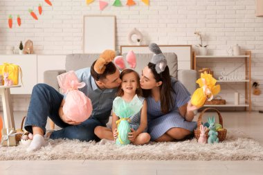 Tavşan kulaklı mutlu aile Paskalya hediyeleri evde yerde oturuyor.