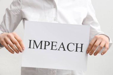 Beyaz arka planda IMPEACHMENT pankart posteri tutan kadın