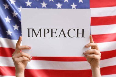IMPEACH pankart posterini arka planda tutan kadın.
