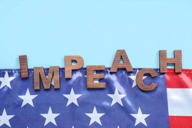 Ahşap harfler mavi arka planda IMPEACHMENT ve ABD bayrağı