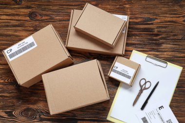 Ahşap masa üzerinde etiket ve pano olan karton paketler